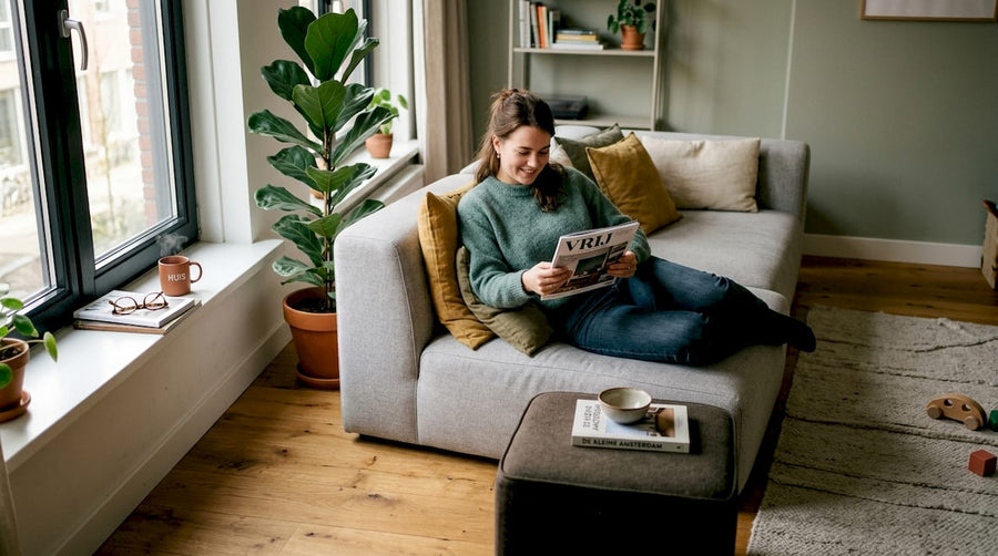 Een vrouw zit ontspannen te lezen op een stijlvolle, moderne bank die uit verschillende modules bestaat.